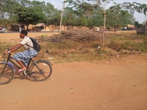 Elève fille sur vélo allant à l'école à Vakon, Porto Novo, Bénin