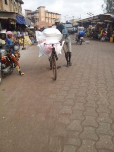 Un cycliste transportant des sacs de farine de bl&eacute;, au march&eacute; Ouando, Porto Novo, B&eacute;nin